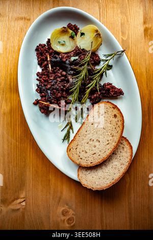 Schwarzer Pudding mit Rosmarin und Zwiebeln Stockfoto