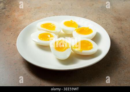 Ein Blick auf Hälften von 7 Minuten hart gekochten Eiern, auf einem Teller. Stockfoto