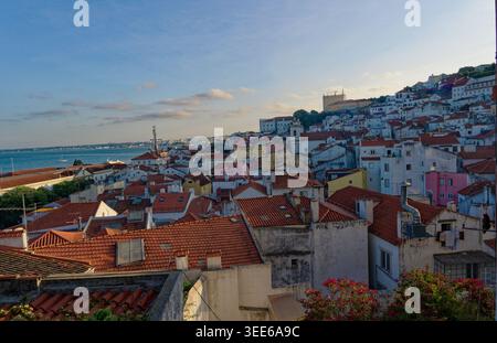 Panoramablick auf die Dächer von Alfama und den Tejo bei Sonnenuntergang in Lissabon Stockfoto