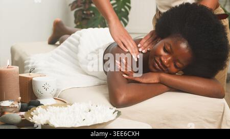 Entspannende Spa-Massage Für Frauen Mit Afro-Haar, Die Aromatherapie-Behandlung Genießen Stockfoto