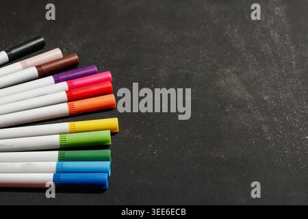 Bunte Marker auf dunklem Hintergrund. Bildungs- und Kreativitätskonzept. Schulungsraum- und Bürobedarf. Hochwertige Fotos Stockfoto
