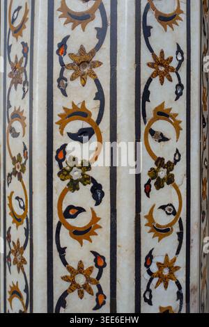 Nahaufnahme komplizierter floraler Motivmotive aus Pietra Dura-Stein auf weißer Marmorsäule der Mogul-Architektur in Indien Stockfoto