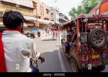 Geschäftige Straßenszene in Alt-Delhi Indien mit Fahrrad-Rikschas und Auto-Rikschas, die durch ein überfülltes Stadtgebiet fahren Stockfoto