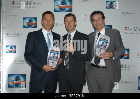 Rene Obermann, Vorstand von T-Mobile, RTL-Chefmoderator Peter Kloeppel und RTL-Informationsdirektor Hans Mahr nehmen an einem Fototermin in Hamburg teil. Die Veranstaltung ist eine Pressekonferenz von RTL und T-Mobile zum Thema Zukunft der TV-Nachrichten. Die drei Männer posieren mit großen Modellen von Mobiltelefonen. 2004. Stockfoto