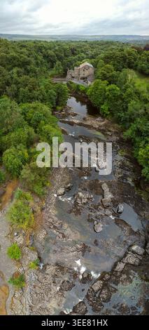 Luftvertorama des Flusses ure schlängelt sich durch felsige Stromschnellen vorbei an Aysgarth Mill und dichten Wäldern Stockfoto