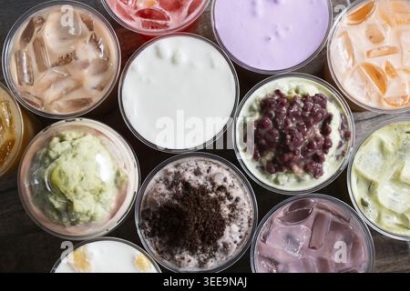 Eine Ansicht von oben nach unten auf einen Hintergrund mehrerer Sorten von Milchtee-Getränken. Stockfoto