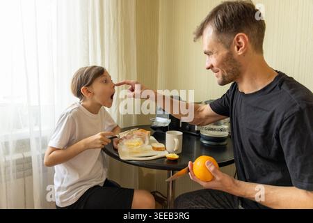 Vater spielt mit Tochter beim Frühstück Stockfoto