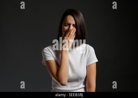 Frau, die weint und das Gesicht bedeckt Stockfoto