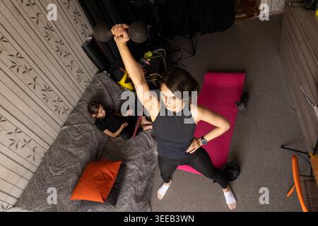 Hochwinkelansicht einer Frau, die die Kurzhantel über sich hebt Stockfoto