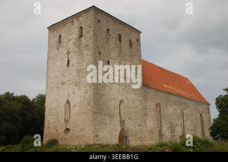 Historische mittelalterliche Steinkirche im ländlichen Estland mit einem riesigen quadratischen Turm, gotischer Architektur und einem traditionellen roten Ziegeldach Stockfoto