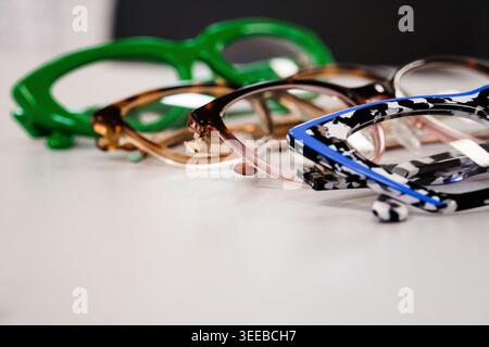 Mehrere stilvolle Brillengestelle in Reihe auf klarem Hintergrund angeordnet. Mode, Sehpflege, Optometriekonzept Stockfoto