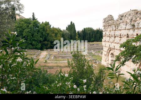 Antike römische Ruinen mit Steinmauern und Säulen in grüner mediterraner Landschaft. Historische archäologische Stätte mit antiken Überresten Stockfoto