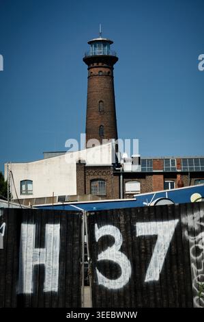 Köln, Deutschland April 30 2026: Der historische Leuchtturm Helios in Köln-Ehrenfeld hinter dem Zaun des Vereins Helios37. Kulturerbe Stockfoto