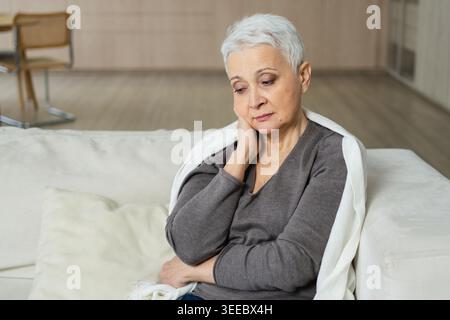 Traurig müde krank krank einsam enttäuscht ältere ältere Frau, die allein zu Hause sitzt. Unglückliche, reife Großmutter erlebt Trauer relativer Tod schlechte Nachrichten. Gestresste ältere Dame, die unter Einsamkeit leidet Stockfoto