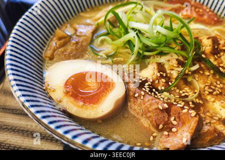 Vegetarischer Tofu-Ramen mit Miso-Brühe, weich gekochtem Ei, Bambussprossen, Sojasprossen, Zwiebeln und Frühlingszwiebeln in japanischer Nudelsuppe Stockfoto