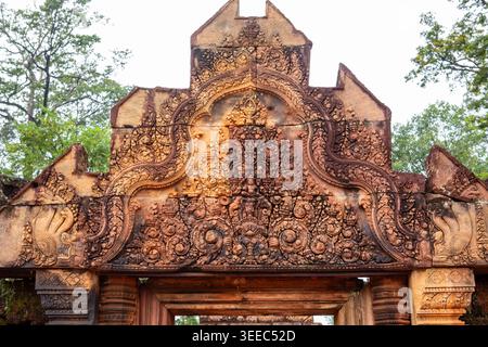 Roter Sandsteingiebel des Tempels Banteay Srei in Angkor, Kambodscha. Das komplizierte Basrelief zeigt den hinduistischen Gott Indra auf seinem dreiköpfigen Elefanten Airav Stockfoto