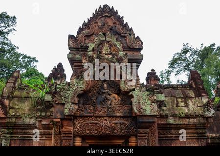 Gemeißelter roter Sandsteingiebel des Tempels Banteay Srei in Angkor, Kambodscha. Die komplizierte Schnitzerei zeigt den Gott Shiva Nataraja in seinem kosmischen Tanz Suruu Stockfoto