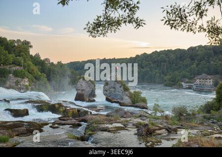 Schnell fließender Fluss über Felsen umgeben von grünen Wäldern und natürlicher Vegetation. Stockfoto