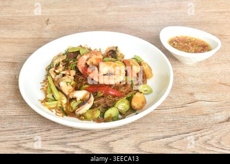 Gebratene Glasnudeln mit drei stinkenden Gemüsesorten und Garnelenpaaren Tintenfischen auf Teller mit würziger Chili-Sauce Stockfoto