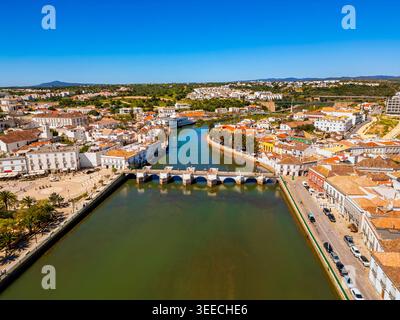 Hochwinkeldrohne Point of View auf der Altstadt von Tavira, Algarve, Portugal mit dem Fluss Gilão und der berühmten mittelalterlichen römischen Brücke Ponte Romana Stockfoto