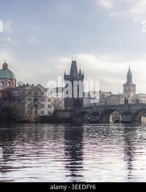 Blick auf die Karlsbrücke und den Altstädter Brückenturm über die Moldau mit historischer Architektur unter hellem Himmel Prag, Prag, Tschechien. Stockfoto