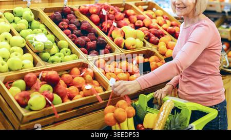 Frau, die tagsüber frisches Obst und Gemüse auf einem Markt kauft Stockfoto