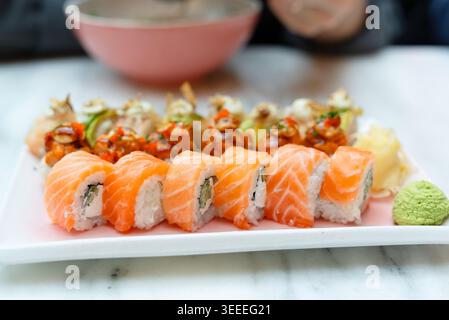 Reichlich Sushi-Platte mit Lachs-Nigiri und Miso-Suppe auf einem weißen Marmortisch. Vielfältige japanische Küche mit frischem Sashimi in eleganter Anordnung. Großzügige asiatische Küche mit appetitlicher Auswahl Stockfoto