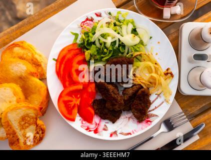 Türkische Kofte, gegrillte Kalbfleischbällchen mit Gemüse und Brot Stockfoto