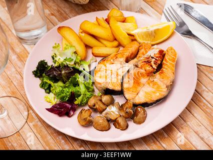 Gebratener Lachs mit gebratenen Kartoffeln und Pilzen, niemand Stockfoto