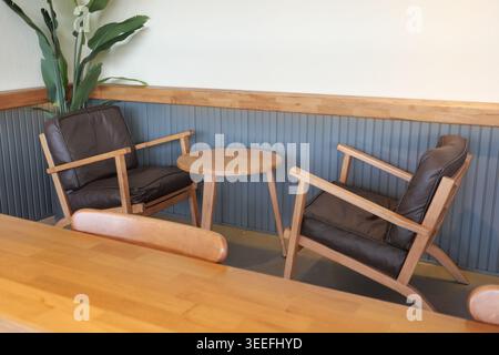 Gemütliche Ecke mit Holzstühlen und kleinem Tisch im Café Stockfoto