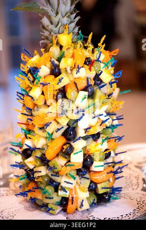 Viele Kanapees mit exotischen Früchten - Kiwi, Trauben, Mandarinen, Ananas. Die ursprüngliche Ablage von Obstsnacks bei der Feier. Catering im Freien, Sommer Stockfoto