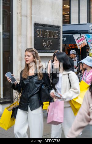 Käufer, die Markentaschen vor dem Kaufhaus Selfridges in der Oxford Street im Londoner West End transportieren. Stockfoto