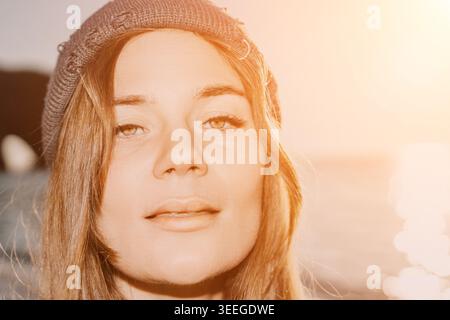 Frau Portrait Beanie, Nahaufnahme einer jungen blonden Frau, die einen gestrickten Hut im Freien während des Sonnenuntergangs der goldenen Stunde trägt. Stockfoto