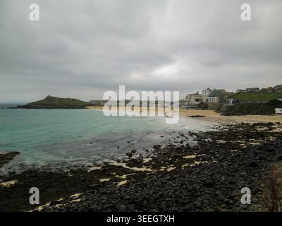 Porthmeor Beach Allgemeine malerische Aussicht auf St. Ives in Cornwall, England, mit malerischen Sandstränden und traditioneller Architektur am Meer. St. Ives ist bekannt für sein künstlerisches Erbe, seine Schönheit an der Küste und seinen lebhaften Tourismus. Es ist eines der beliebtesten Reiseziele Großbritanniens und zieht Besucher das ganze Jahr über mit seiner dramatischen Küste und seiner entspannten maritimen Atmosphäre an. Stockfoto