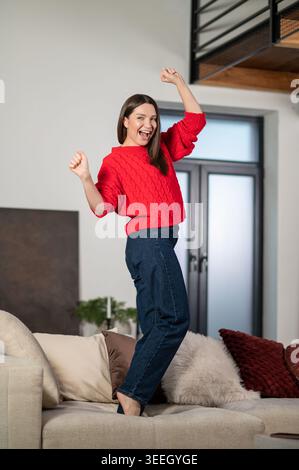 Junge hübsche Frau, die sich aufgeregt fühlt und zu Hause Spaß hat Stockfoto