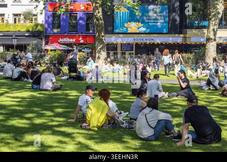 Menschenmenge, die sich auf dem Gras auf einem Stadtplatz entspannt. London, UK, 2. Juni 2024 Stockfoto