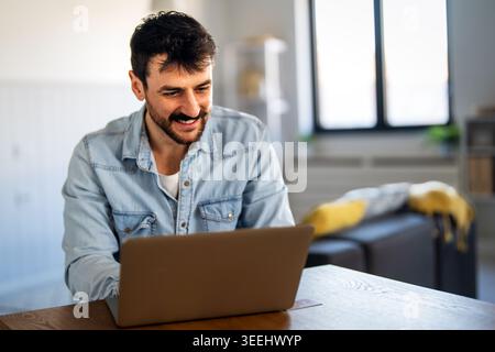 Ein Mann, der Remote vom Home Office aus arbeitet, ein Online-Meeting abhält, flexible freiberufliche Arbeit genießt Stockfoto