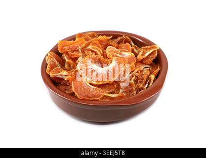 Getrocknete Segmente von Clementinen in einer Keramikschale auf weißem Hintergrund. Stockfoto