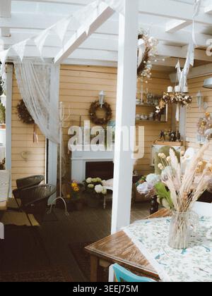 Das Ott and Matilda Cafe ist im Vintage-Stil eingerichtet und verfügt über Spitzenfahnen, getrocknete Blumen und rustikale Einrichtung in Estland Stockfoto