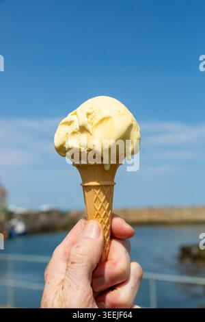 Nahaufnahme eines schmelzenden Vanilleeises in einem traditionellen Waffelkegel Stockfoto