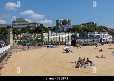 Menschenmassen genießen Bournemouth Beach, Dorset, England - lebhafte Sommerszene mit Hotels und Promenade im Blick. Stockfoto