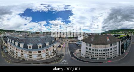 Blick aus der Vogelperspektive auf das historische Stadtzentrum mit verzierten Dächern, urbanen Straßen und umliegenden Hügeln unter bewölktem Himmel in Biel Bienne, Kanton B Stockfoto