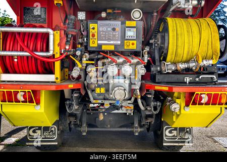 Dijon, Frankreich - 9. Mai 2026: Nahaufnahme der hinteren Steuertafel an einem Feuerwehrfahrzeug mit verschiedenen Ventilen und Manometern. Schläuche in Rollen bereit gelagert. Stockfoto