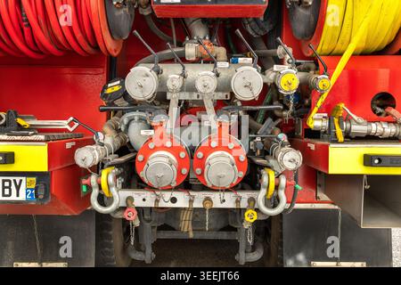 Dijon, Frankreich - 9. Mai 2026: Nahaufnahme der hinteren Steuertafel an einem Feuerwehrfahrzeug mit verschiedenen Ventilen und Manometern. Schläuche in Rollen bereit gelagert. Stockfoto
