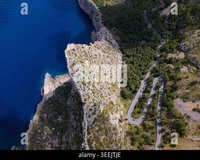 Blick aus der Vogelperspektive auf die gewundene Straße am Cap de Formentor mit Haarnadelkurven entlang steiler Felsklippen mit Blick auf das tiefblaue Meer in Balearen, Spa Stockfoto
