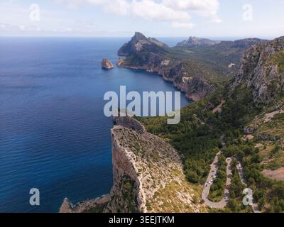 Aus der Vogelperspektive auf Cap de Formentor mit steilen Kalksteinklippen, einer gewundenen Bergstraße und dem tiefblauen Mittelmeer, den Balearen, Spanien. Stockfoto