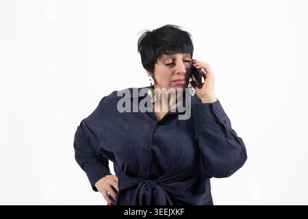 Frau in blauem Hemd, die auf dem Smartphone spricht, lächelt für professionelle Medienprofis... Stockfoto