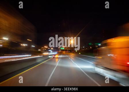 Bewegungsunschärfe von Stadtlichtern durch bewegliches Auto bei Nacht für kommerzielle Lagerbestände Stockfoto