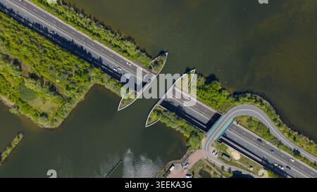 Aus der Vogelperspektive des Aquadukts Veluwemeer mit Autos, die durch den Tunnel unter dem Kanal fahren, umgeben von grünen Bäumen und ruhigem Wasser Harderwijk, Gelderlan Stockfoto