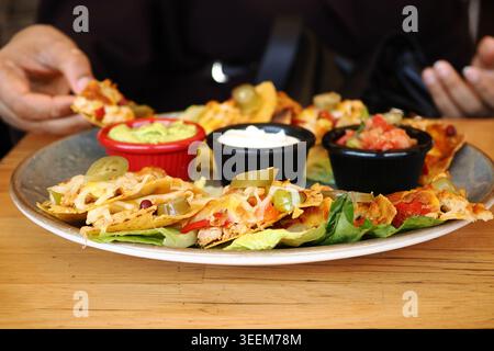 Nachos serviert mit Dips in einem zwanglosen Restaurant Stockfoto